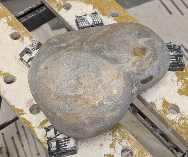 an abstract sculpture made from alabaster. it resembles a heart and a butt