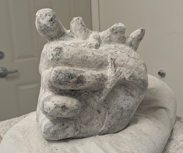 a sculpture depicting a head being held by a hand with brains oozing out of it