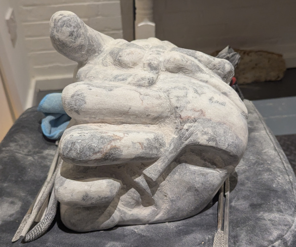 a sculpture depicting a head being held by a hand with brains oozing out of it