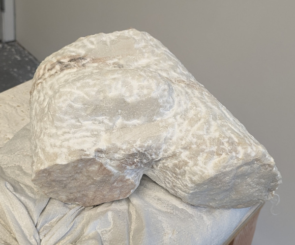 a sculpture made from marble showing a nude male figure