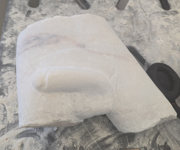 a sculpture made from marble showing a nude male figure