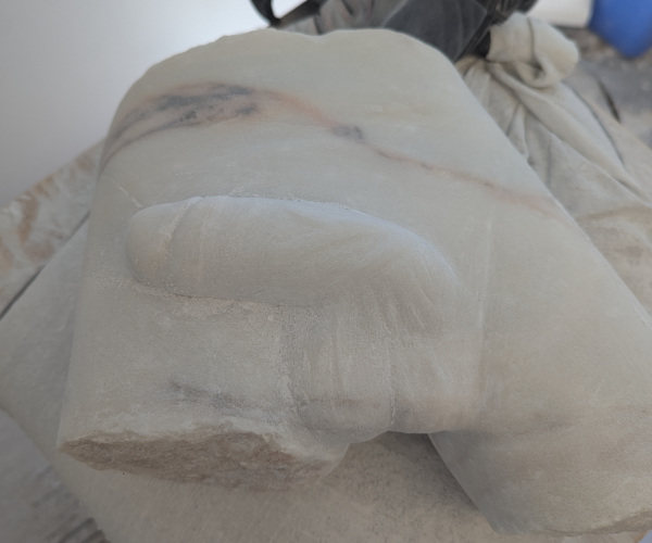 a sculpture made from marble showing a nude male figure